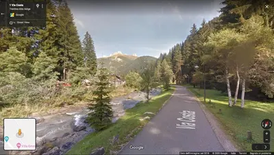 a road with trees and a river and a mountain at Appartamento MARMOLADA - CANAZEI in Canazei