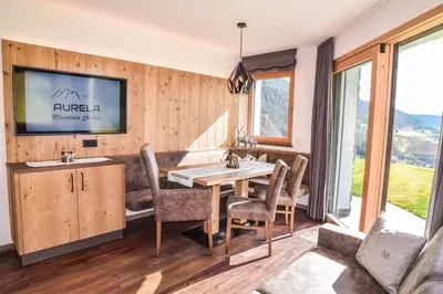 a dining room with a table and chairs at Aurela Mountain Chalets in Selva di Val Gardena