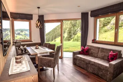 a living room with a couch and a table at Aurela Mountain Chalets in Selva di Val Gardena