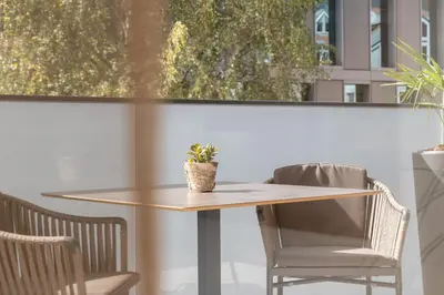 a table with two chairs and a potted plant on it at Nice Living Neue- Moderne Apartments im Herzen von Brixen - kostenlose Brixencard - ideal für Familien, Paare, Geschäftsreisende und allen Urlaubs Hungrigen in Bressanone