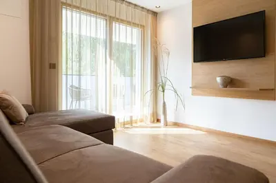 a living room with a couch and a large window at Nice Living Neue- Moderne Apartments im Herzen von Brixen - kostenlose Brixencard - ideal für Familien, Paare, Geschäftsreisende und allen Urlaubs Hungrigen in Bressanone