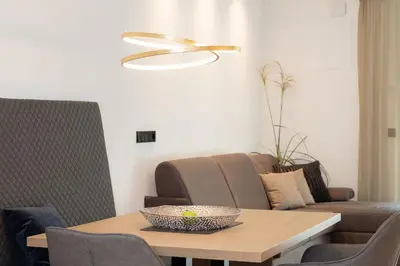 a living room with a table and a couch at Nice Living Neue- Moderne Apartments im Herzen von Brixen - kostenlose Brixencard - ideal für Familien, Paare, Geschäftsreisende und allen Urlaubs Hungrigen in Bressanone