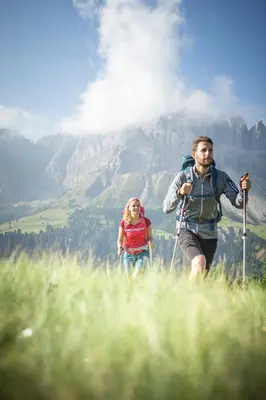 a man and a woman hiking on a mountain at Nice Living Neue- Moderne Apartments im Herzen von Brixen - kostenlose Brixencard - ideal für Familien, Paare, Geschäftsreisende und allen Urlaubs Hungrigen in Bressanone