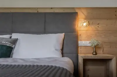 a bedroom with a bed with a white pillow and a lamp at Apartment Dolomites Nest in San Martino in Badia