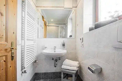 a white bathroom with a sink and a mirror at Apartment Dolomites Nest in San Martino in Badia