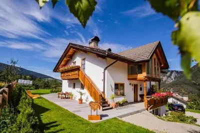 a small white house with a roof at Apartment Dolomites Nest in San Martino in Badia