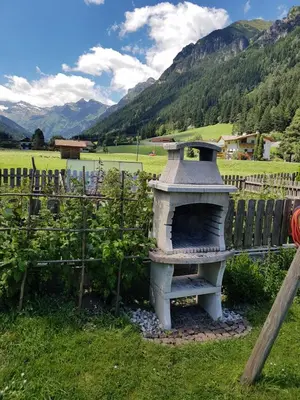 a stone oven in a field next to a fence at Ottohof - Feldblick in Colle Isarco
