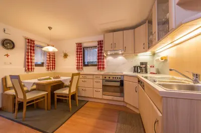 a kitchen with a table and a dining room at Ottohof - Feldblick in Colle Isarco