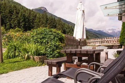 a patio with a table and an umbrella at Ottohof - Feldblick in Colle Isarco