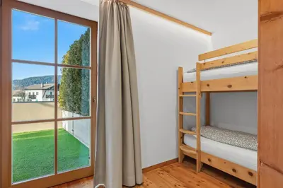 a bedroom with bunk beds and a large window at Apartment Panorama Val di Non in San Felice