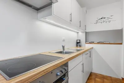 a kitchen with white cabinets and a sink at Apartment Panorama Val di Non in San Felice
