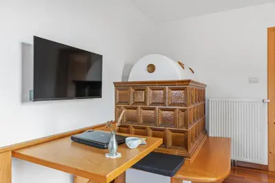a room with a table with a tv and a wooden cabinet at Apartment Panorama Val di Non in San Felice