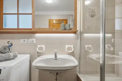 a white bathroom with a sink and a shower at Apartment Panorama Val di Non in San Felice