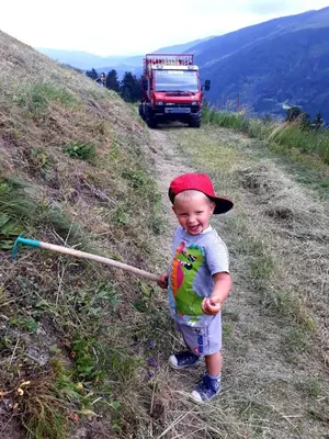 a young boy holding a rake on a hill at Felderhof in Maranza