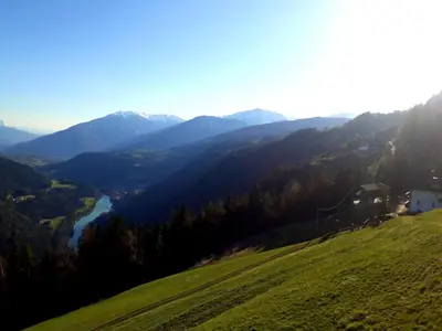 a green hillside with a view of a river and mountains at Felderhof in Maranza