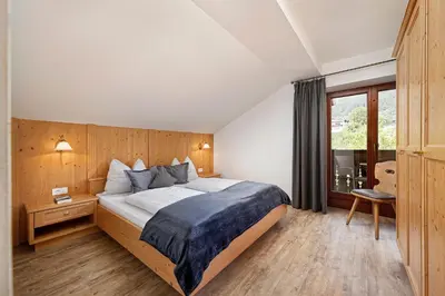 a bedroom with a large bed and a window at Schlettererhof in Tirolo