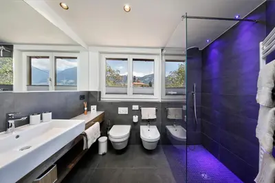 a bathroom with two toilets and a sink and a shower at Schlettererhof in Tirolo