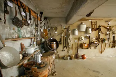 a room with a bunch of utensils on the wall at Schlettererhof in Tirolo