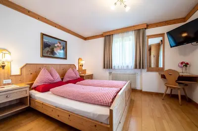 a bedroom with a large bed with red pillows at Gasthof Bauhof in Brunico