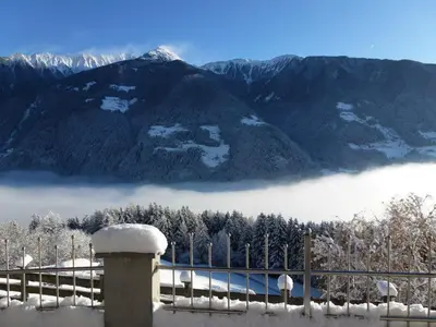 a snow covered mountain with a fence in front of it at Gasthof Bauhof in Brunico