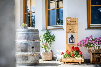a wine barrel and flowers outside of a building at Gasthof Bauhof in Brunico