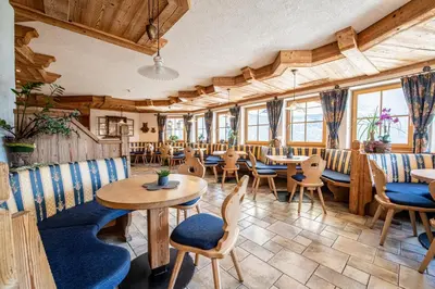 a restaurant with tables and chairs and windows at Gasthof Bauhof in Brunico