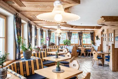 a restaurant with tables and chairs and windows at Gasthof Bauhof in Brunico