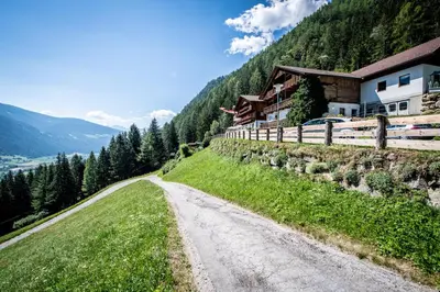 a dirt road next to a house on a mountain at Gasthof Bauhof in Brunico