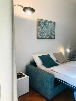 a bed with a blue couch in a room at villa Mays in Merano