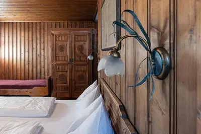 a room with two beds and a light on a wall at Gasthof Residence Brugghof & Erlhof in Campo Tures