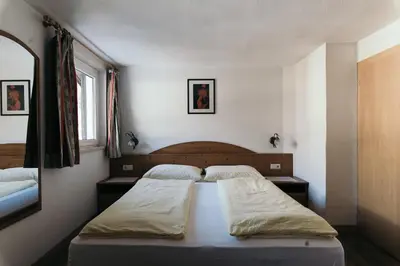 a bedroom with two beds and a mirror at Gasthof Residence Brugghof & Erlhof in Campo Tures