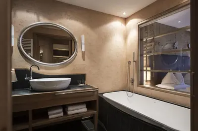 a bathroom with a sink and a tub and a mirror at Adler Spa Resort Balance in Ortisei