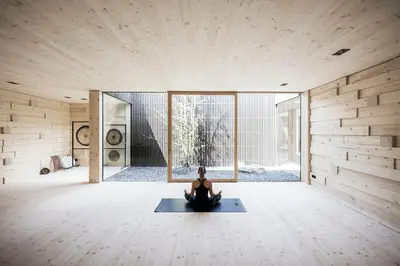 a woman sitting on a yoga mat in a room at Adler Spa Resort Balance in Ortisei