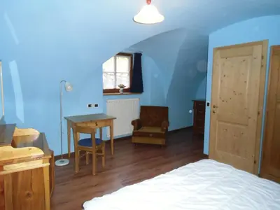 a bedroom with blue walls and a bed and a desk at Rio Gambis Apartment in Cavalese