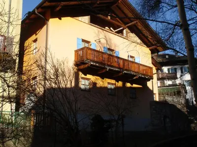 a building with a balcony on the side of it at Rio Gambis Apartment in Cavalese