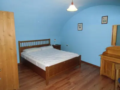 a bedroom with a bed and a blue wall at Rio Gambis Apartment in Cavalese