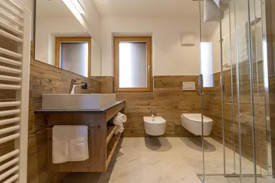 a bathroom with a sink and a toilet and a shower at Luech da Perteut - Panorama and Wellness in Santa Cristina in Val Gardena