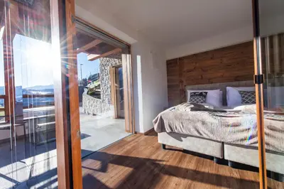 a bedroom with a bed and a sliding glass door at Luech da Perteut - Panorama and Wellness in Santa Cristina in Val Gardena