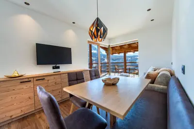 a dining room with a table and a tv at Luech da Perteut - Panorama and Wellness in Santa Cristina in Val Gardena
