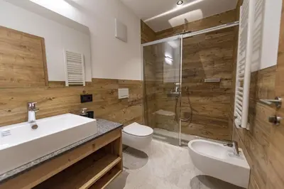 a bathroom with a sink and a toilet and a shower at Luech da Perteut - Panorama and Wellness in Santa Cristina in Val Gardena