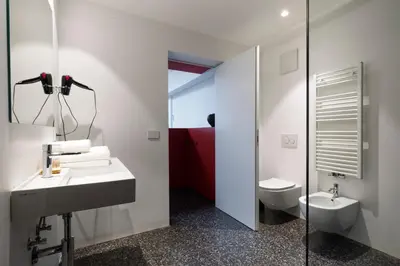 a bathroom with a sink and a toilet and a mirror at Pepper Suite in Bolzano
