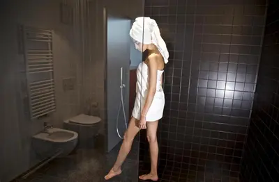 a woman with a towel on her head in a bathroom at Pepper Suite in Bolzano