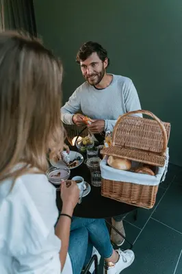 a man and a woman sitting at a table eating food at Floris Green Suites by Parc Hotel Florian in Siusi