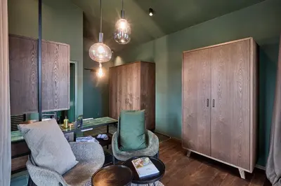 a room with two chairs and a desk and cabinets at Floris Green Suites by Parc Hotel Florian in Siusi