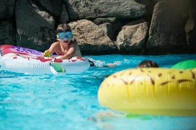 a young child in the water on an inflatable at Hotel Frangart an der Weinstraße in Appiano sulla Strada del Vino