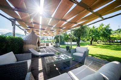 an outdoor patio with a wooden pergola at Hotel Frangart an der Weinstraße in Appiano sulla Strada del Vino
