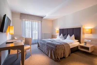 a hotel room with a bed and a desk at Hotel Frangart an der Weinstraße in Appiano sulla Strada del Vino