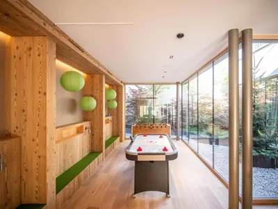 a room with a ping pong table in a house at Falkensteiner Hotel Kronplatz - The Leading Hotels of the World in Brunico