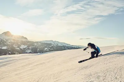 a person is skiing down a snow covered slope at Falkensteiner Hotel Kronplatz - The Leading Hotels of the World in Brunico