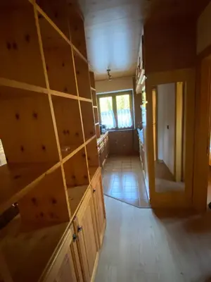 a kitchen with wooden cabinets and a door to a room at Casa Doleda in Alba di Canazei